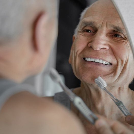 Man brushing his teeth and dental implants