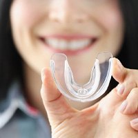 Woman holding a clear mouthguard