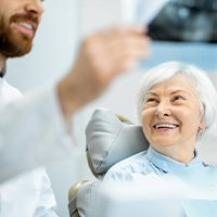 Dentist showing smiling patient the results of her X-ray