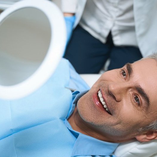 a patient checking his teeth with a mirror